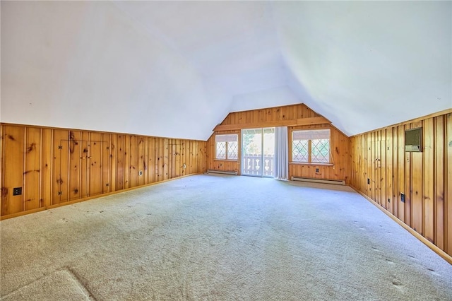 bonus room featuring baseboard heating, wood walls, carpet, and vaulted ceiling