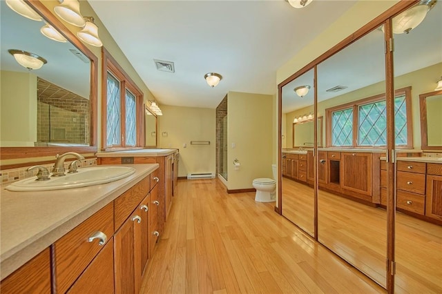 432 Black Forest Rd, Glen Spey, NY 12737 - full bath featuring two vanities, a shower stall, a baseboard heating unit, and wood finished floors