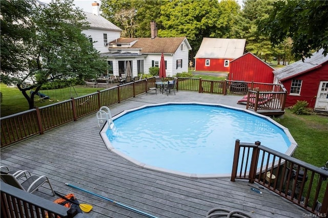 view of swimming pool featuring a lawn and a wooden deck