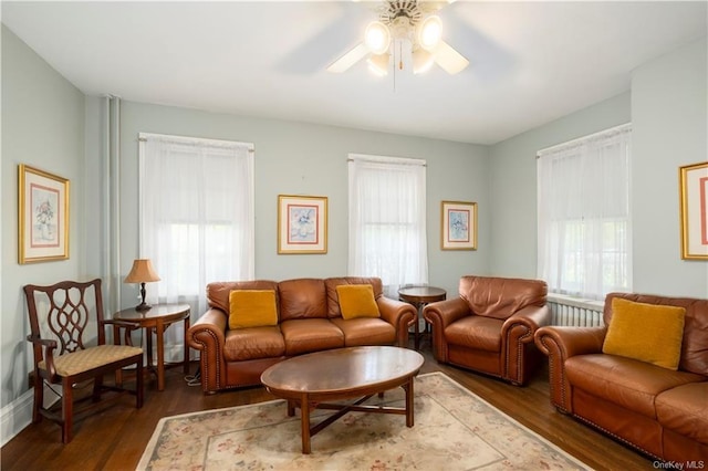 living room featuring ceiling fan, a healthy amount of sunlight, and dark hardwood / wood-style flooring