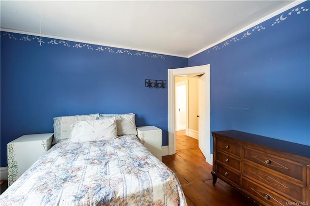 bedroom with hardwood / wood-style floors and crown molding