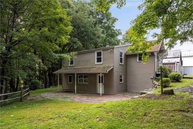 back of house with a lawn and a patio