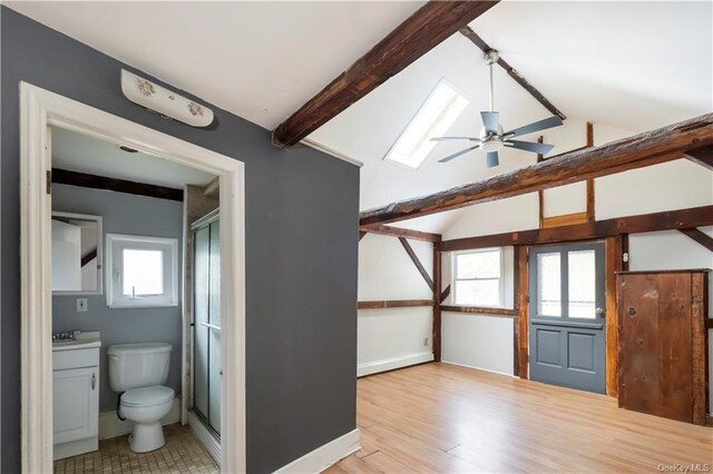 bonus room featuring a skylight, ceiling fan, beamed ceiling, and light wood-type flooring