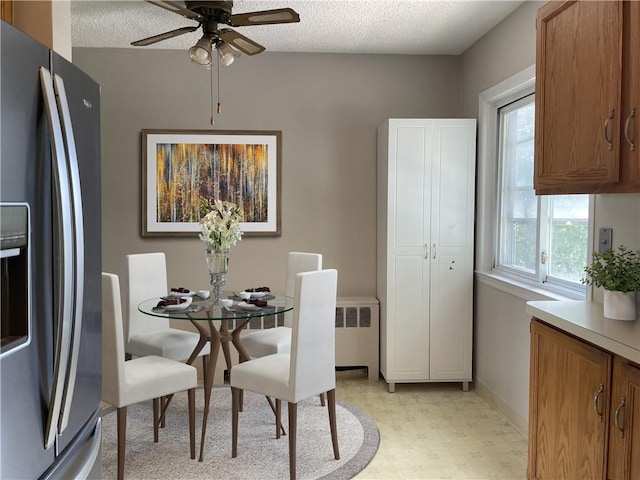 dining area with ceiling fan and a textured ceiling