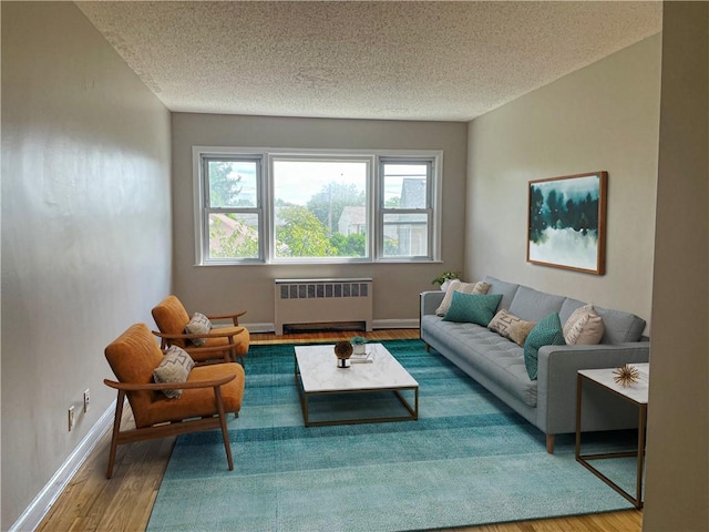 living room with a textured ceiling, hardwood / wood-style flooring, and radiator