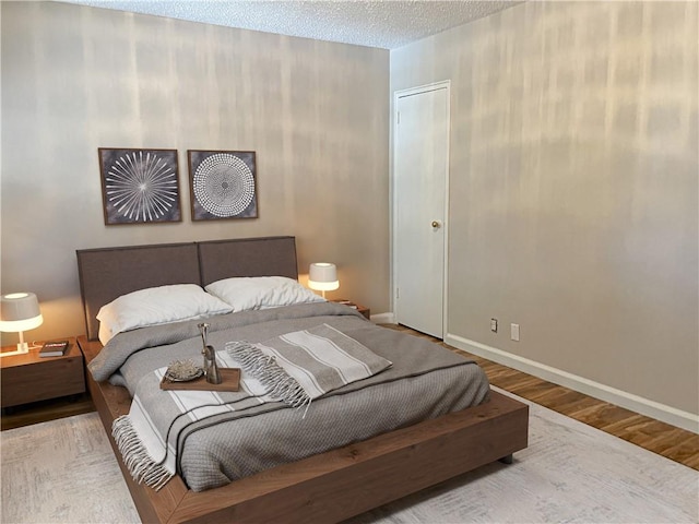 bedroom with wood-type flooring and a textured ceiling