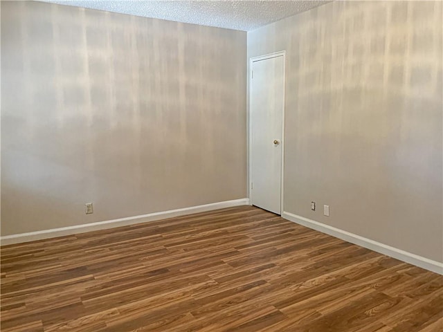 unfurnished room featuring hardwood / wood-style floors and a textured ceiling