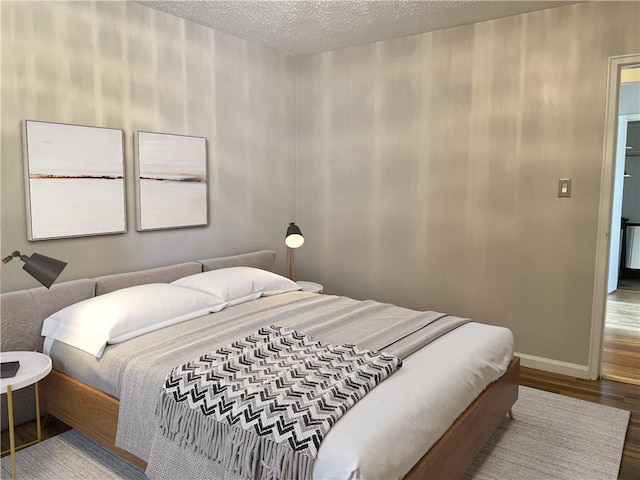 bedroom with hardwood / wood-style floors and a textured ceiling