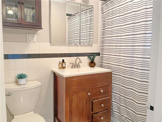 bathroom with tasteful backsplash, vanity, tile walls, and toilet