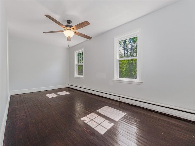 spare room featuring wood-type flooring, a wealth of natural light, and a baseboard heating unit