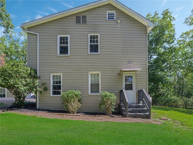 rear view of property featuring a lawn