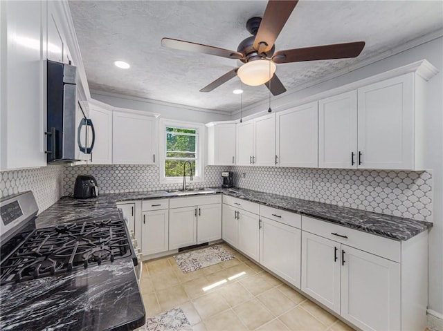 kitchen featuring white cabinets, appliances with stainless steel finishes, decorative backsplash, and sink