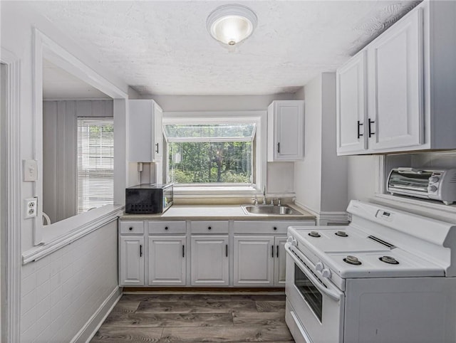 kitchen featuring electric range, sink, white cabinets, and dark hardwood / wood-style floors