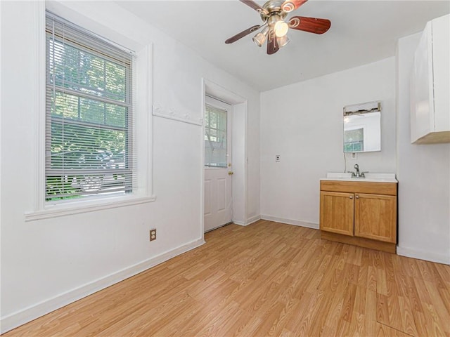 interior space with ceiling fan, light wood-type flooring, and sink