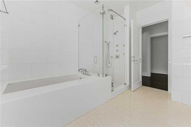 bathroom featuring shower with separate bathtub