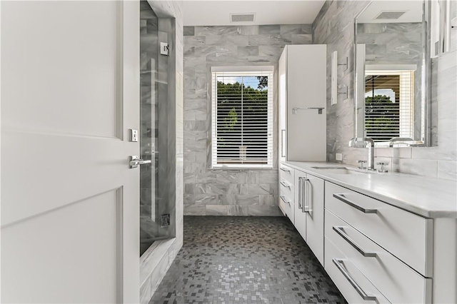 bathroom featuring a shower, vanity, and tile walls