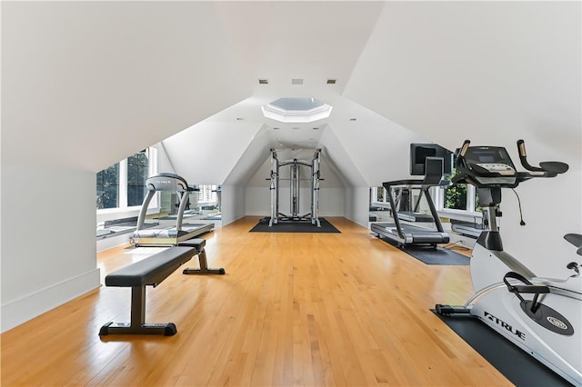 workout room featuring wood-type flooring and vaulted ceiling