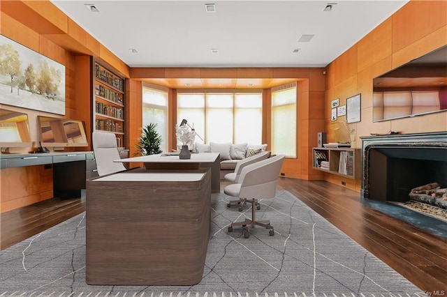 office space with built in shelves and dark hardwood / wood-style flooring