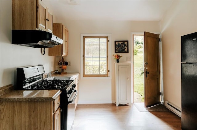 kitchen with light hardwood / wood-style floors, a baseboard radiator, extractor fan, and stainless steel gas range