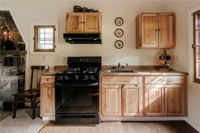 kitchen with black gas stove, light wood-type flooring, sink, and extractor fan