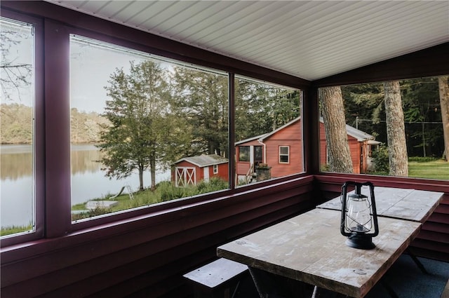 sunroom with a water view and lofted ceiling