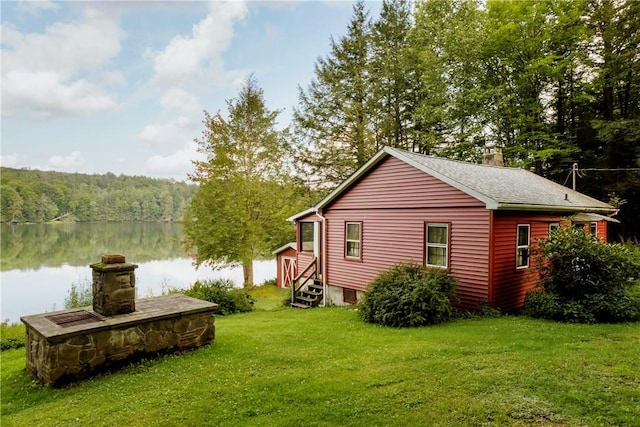 view of side of home with a yard and a water view