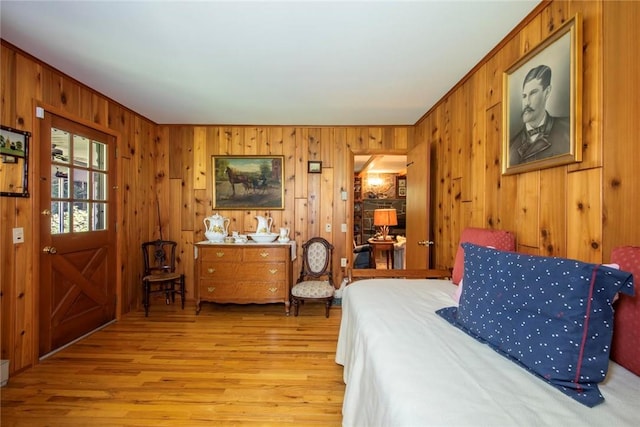 bedroom featuring wood walls and light hardwood / wood-style flooring