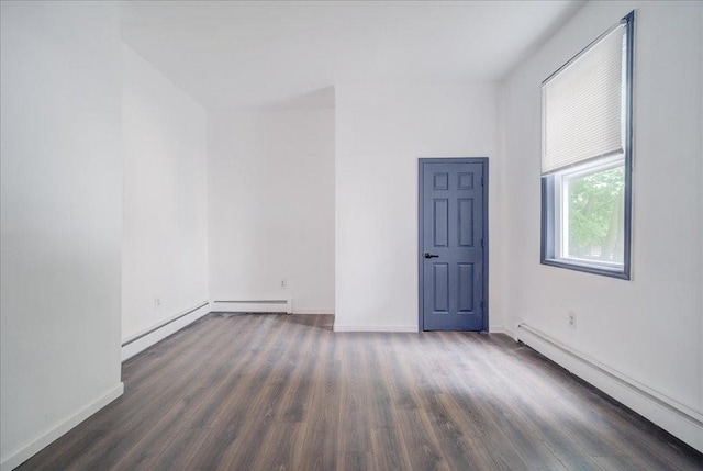 empty room featuring dark hardwood / wood-style flooring and a baseboard radiator