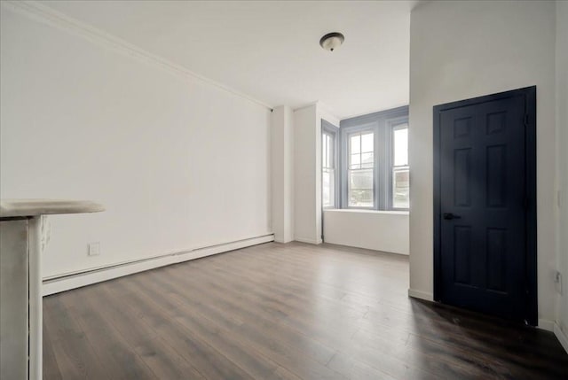 interior space featuring dark hardwood / wood-style flooring, crown molding, and a baseboard heating unit