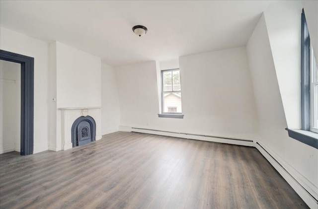 unfurnished living room with dark hardwood / wood-style floors and a baseboard heating unit