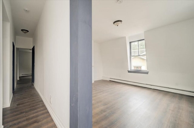 corridor with dark hardwood / wood-style flooring and baseboard heating