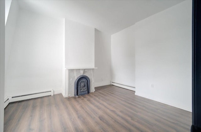 unfurnished living room featuring baseboard heating, a fireplace, and dark hardwood / wood-style floors