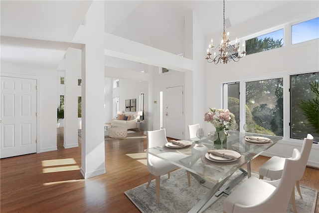 dining space with dark hardwood / wood-style flooring, high vaulted ceiling, and a wealth of natural light