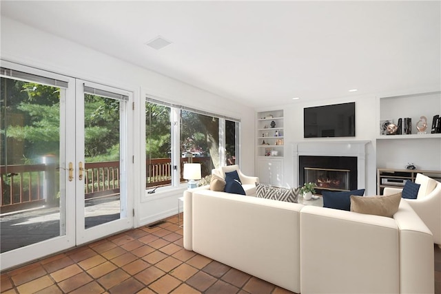 tiled living room featuring built in shelves