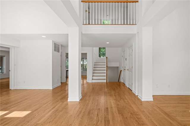 foyer with a towering ceiling and light hardwood / wood-style floors