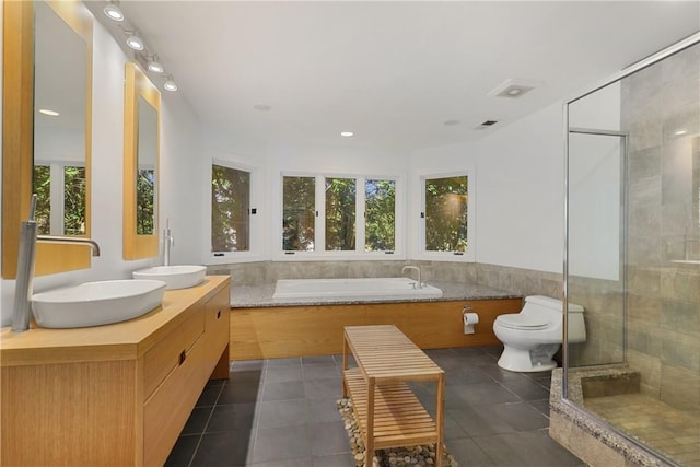 full bathroom featuring tile patterned floors, vanity, independent shower and bath, and toilet