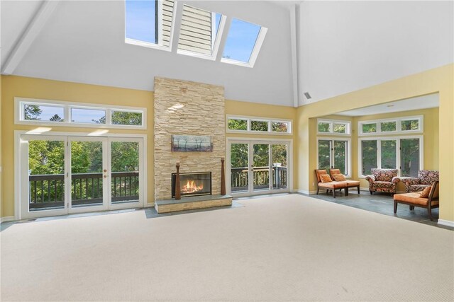 living room with plenty of natural light, carpet floors, high vaulted ceiling, and french doors