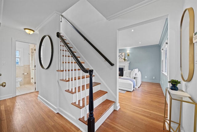 staircase with crown molding and hardwood / wood-style flooring