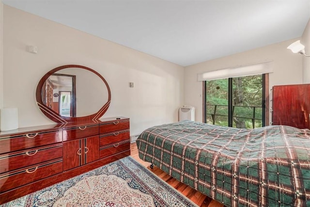 bedroom featuring radiator heating unit and hardwood / wood-style flooring