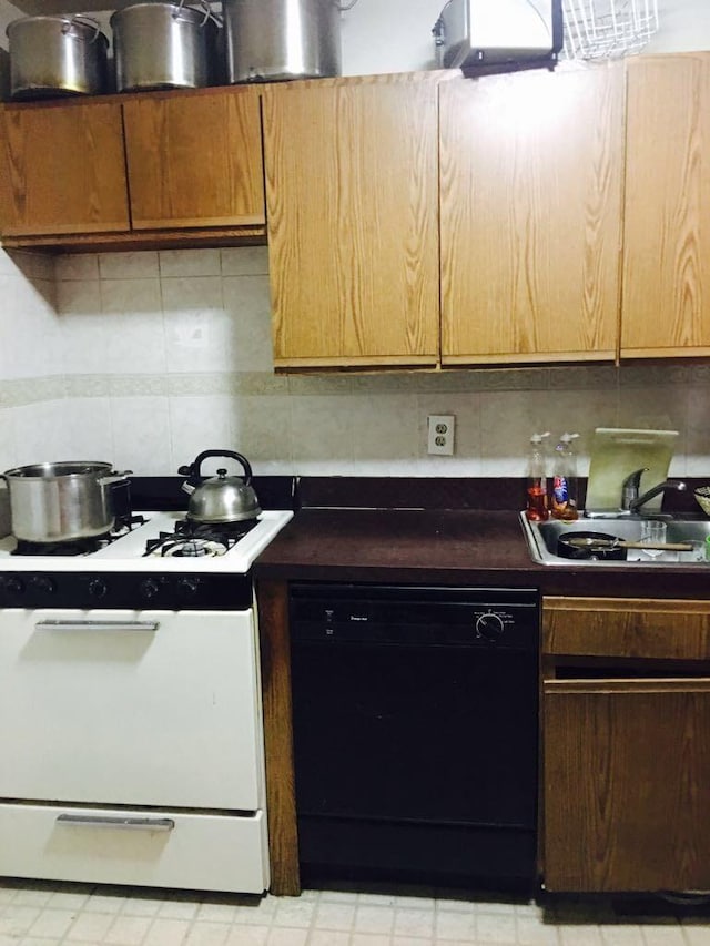 kitchen featuring dishwasher, white range with gas stovetop, tasteful backsplash, and sink