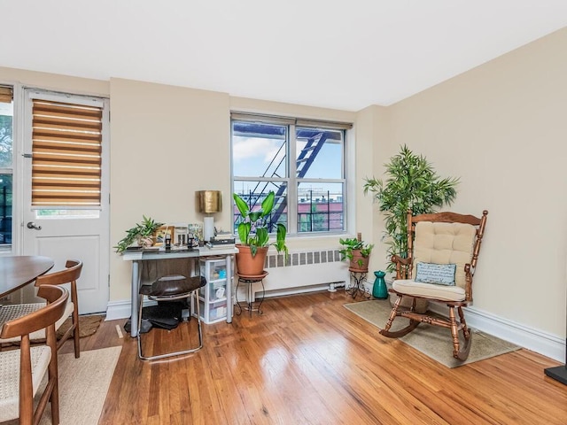 3201 Grand Concourse Unit 2E, Bronx, NY 10468 - living area featuring radiator, wood finished floors, and baseboards