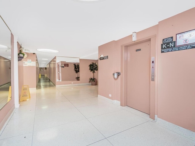 hall with elevator and light tile patterned flooring