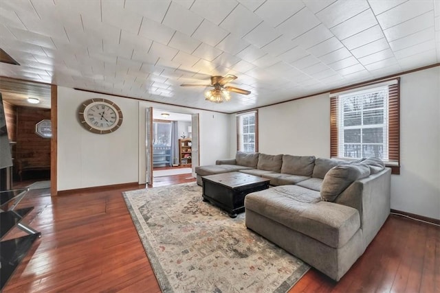 living room featuring ornamental molding, ceiling fan, and dark wood-type flooring