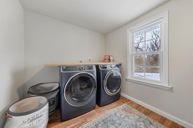 washroom with washer and clothes dryer and light hardwood / wood-style flooring