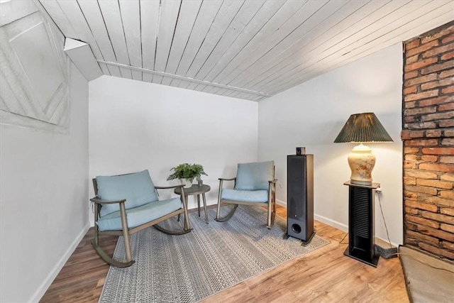 sitting room with hardwood / wood-style floors, wood ceiling, and lofted ceiling