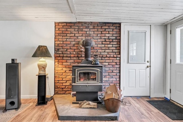 living room featuring light hardwood / wood-style flooring, a wood stove, and wood ceiling