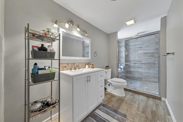 bathroom with vanity, backsplash, hardwood / wood-style flooring, toilet, and walk in shower