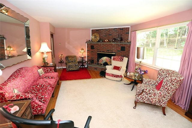 living room featuring hardwood / wood-style flooring and a brick fireplace