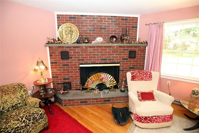 living room with hardwood / wood-style floors and a brick fireplace