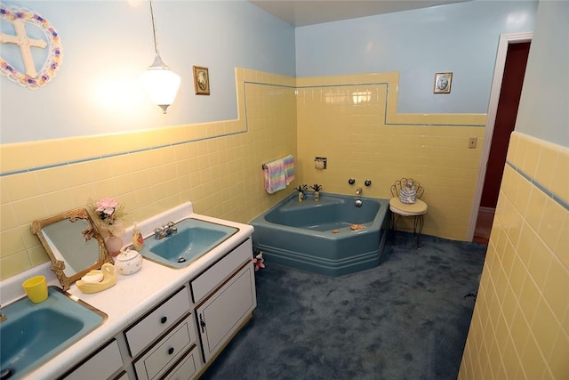 bathroom featuring vanity, a tub to relax in, and tile walls